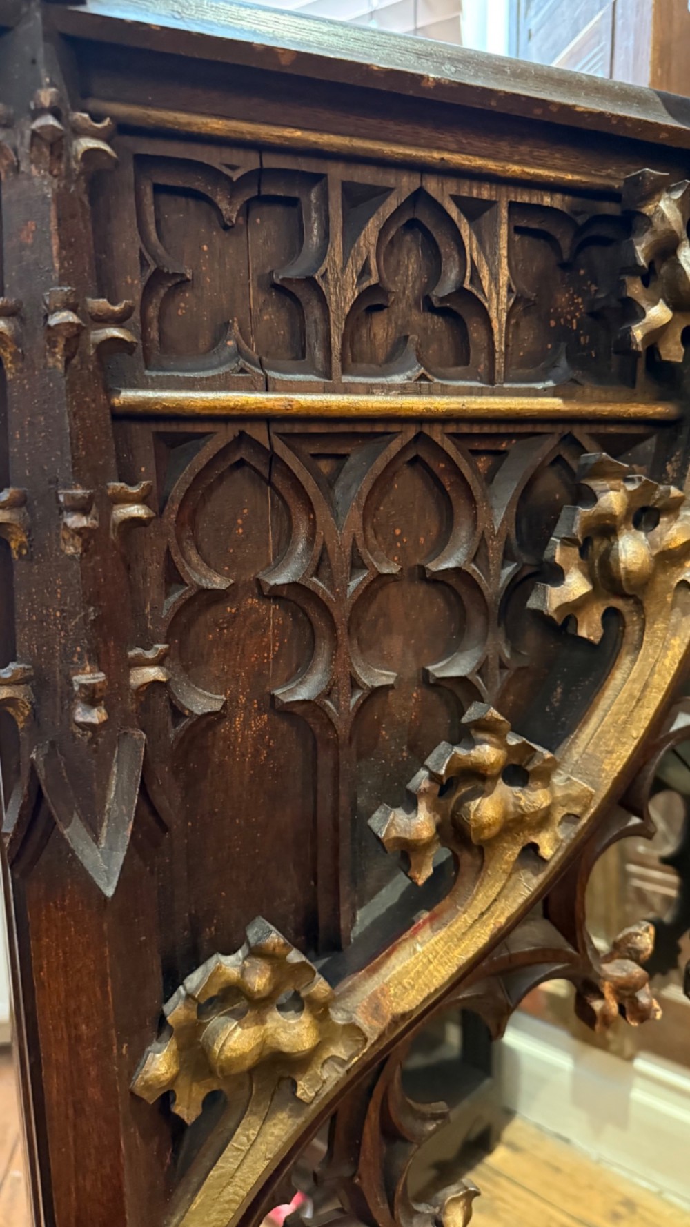 A dark carved oak Gothic Revival mirror frame featuring a pointed arch, intricate tracery, gilded crockets, and decorative finials. View XIV