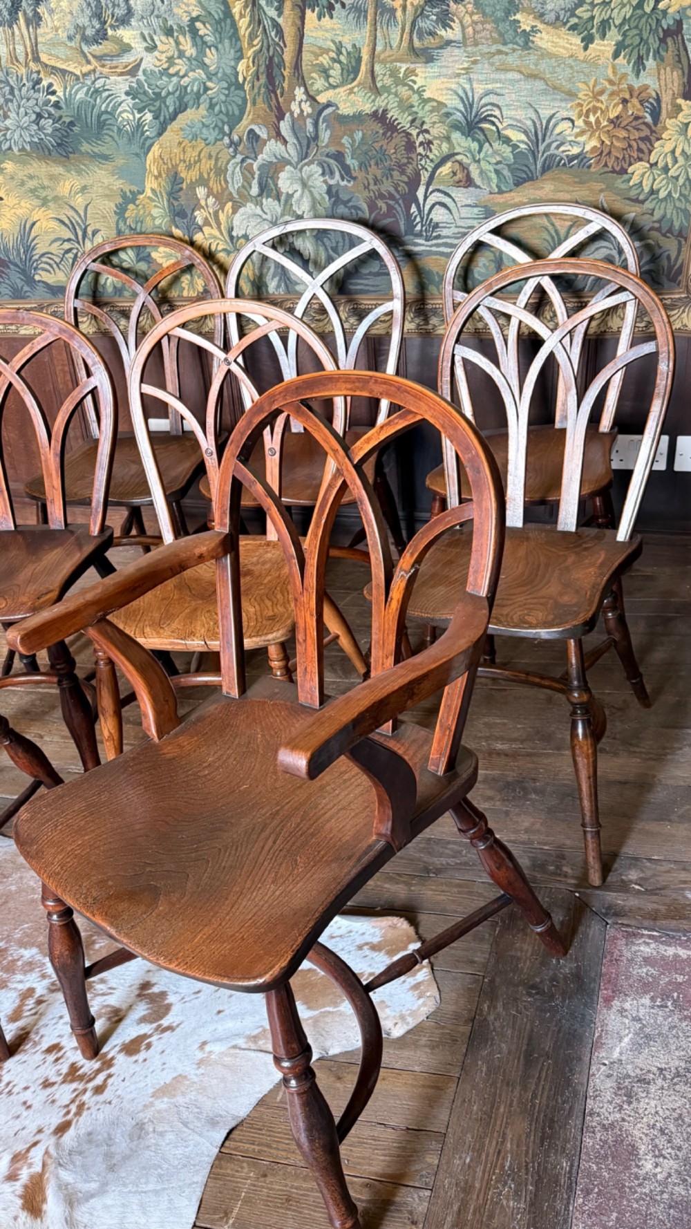 A set of 19th-century Gothic Windsor wooden dining chairs featuring pointed arch back splats, saddle seats, and turned legs. View III