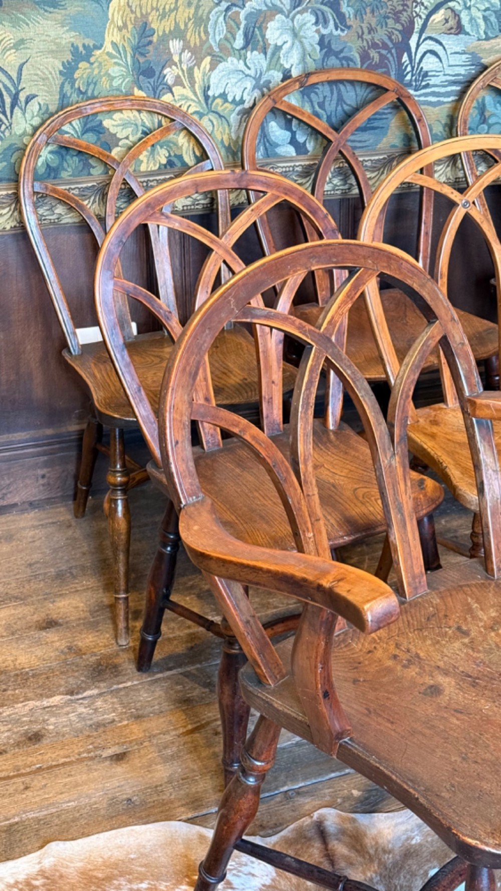 A set of 19th-century Gothic Windsor wooden dining chairs featuring pointed arch back splats, saddle seats, and turned legs. View VII