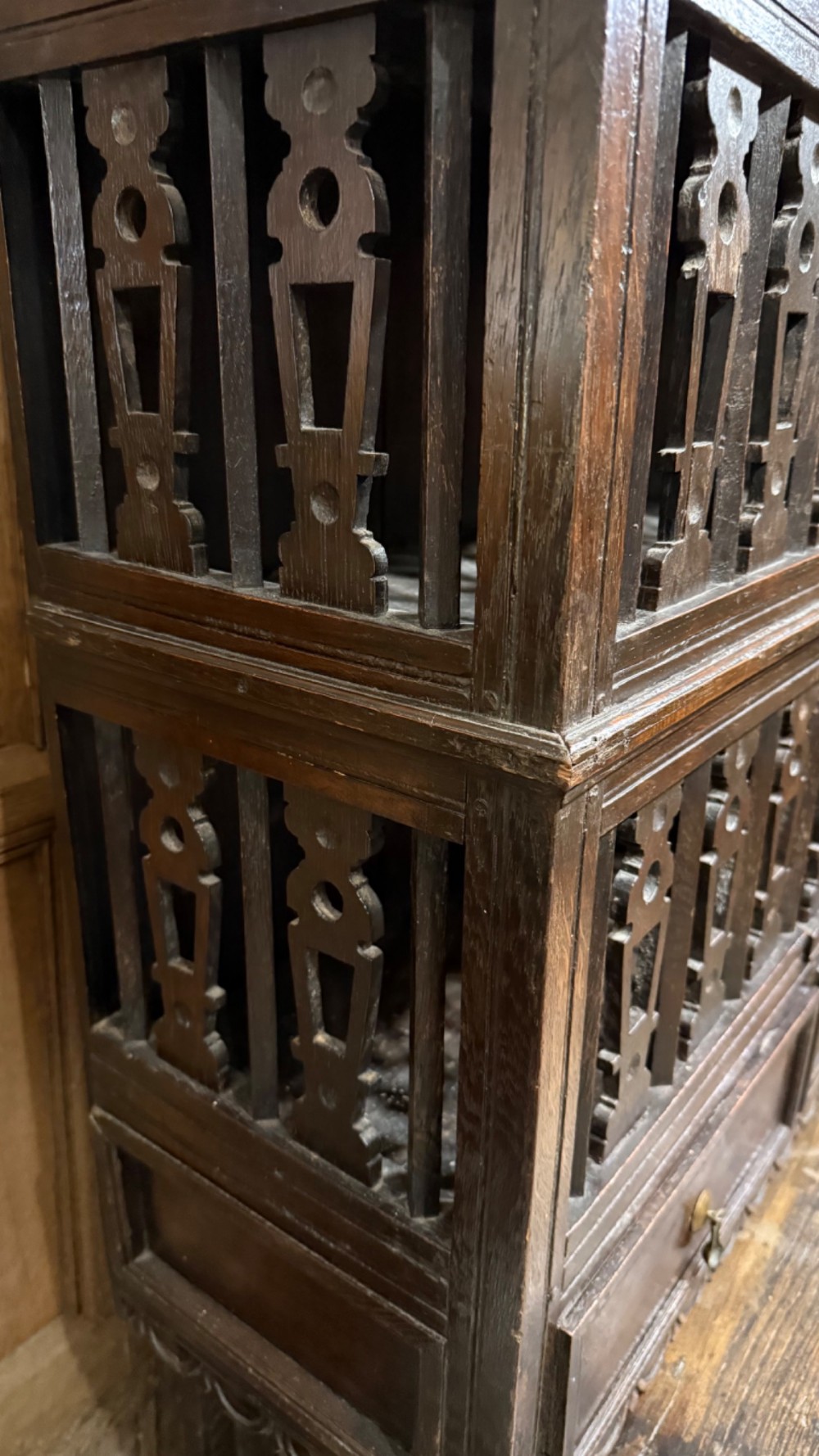 A dark oak seventeenth-century hanging cupboard featuring two upper tiers with carved pierced balusters and three small drawers with teardrop handles along the base. View III