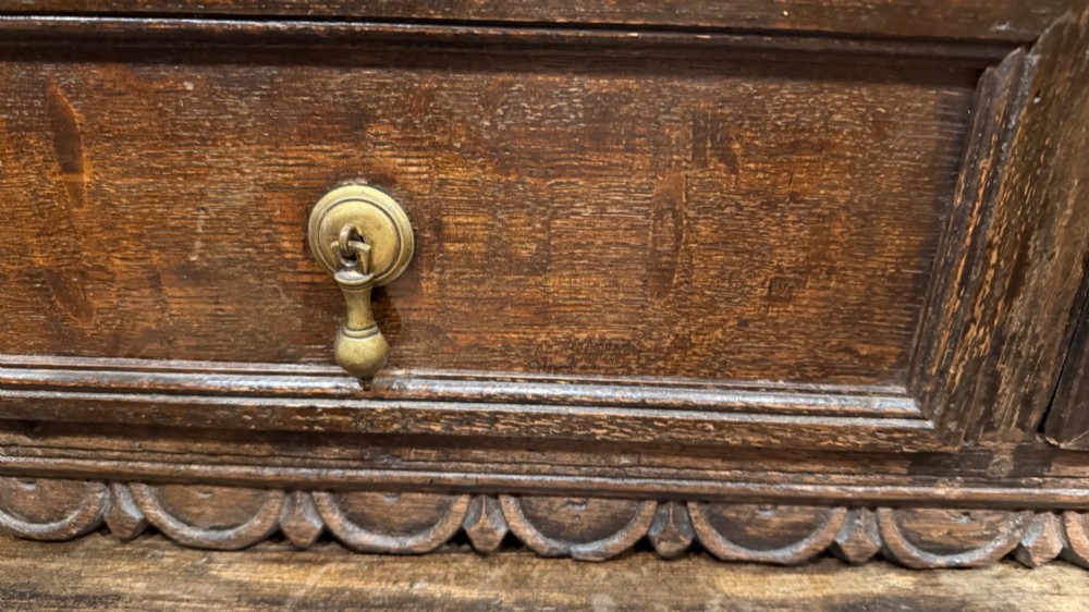 A dark oak seventeenth-century hanging cupboard featuring two upper tiers with carved pierced balusters and three small drawers with teardrop handles along the base. View VIII