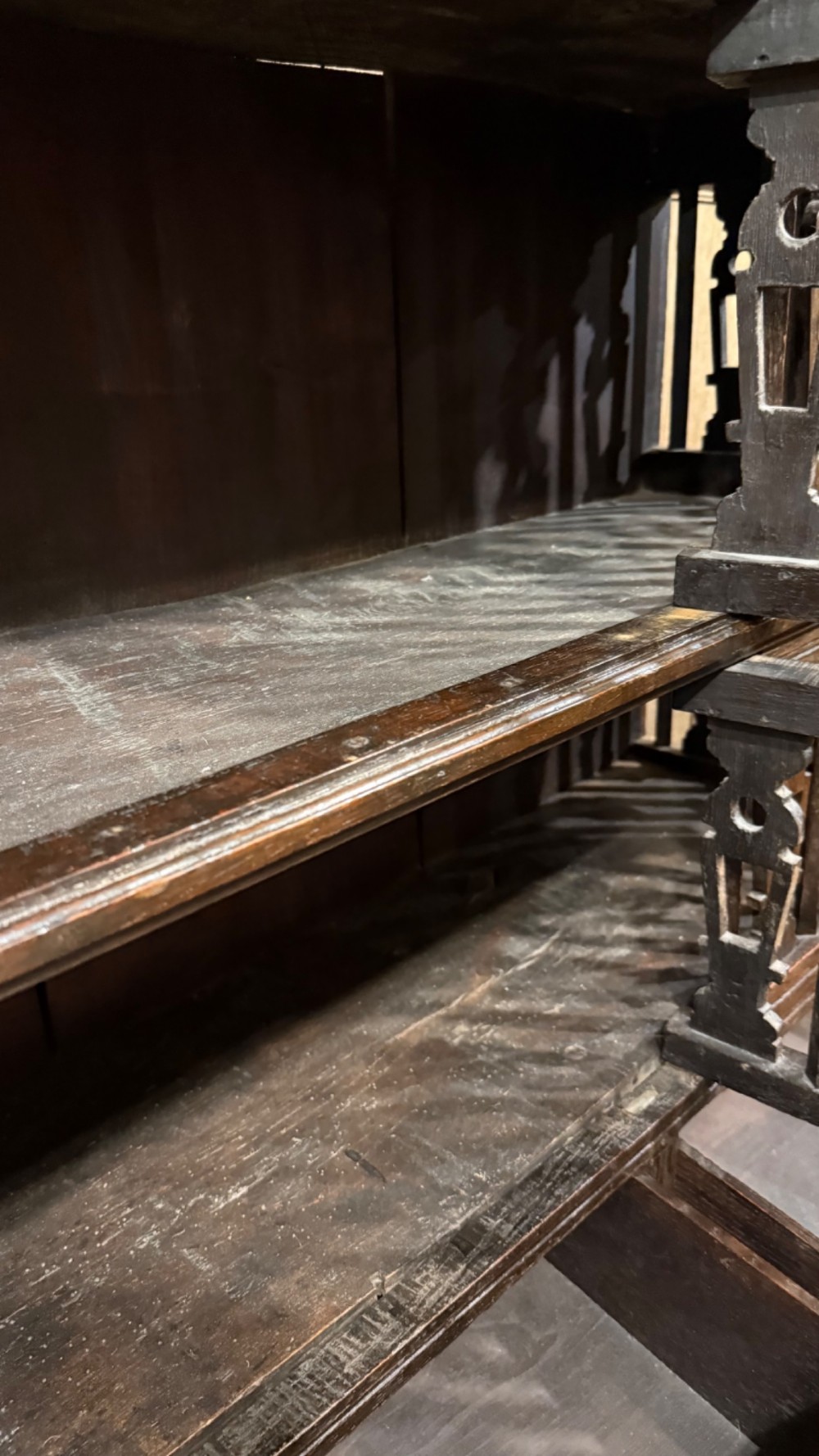 A dark oak seventeenth-century hanging cupboard featuring two upper tiers with carved pierced balusters and three small drawers with teardrop handles along the base. View XV