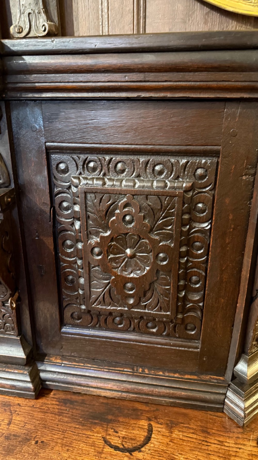 An 18th-century dark oak hanging cupboard featuring carved figural columns, relief door panels with floral motifs, and carved masks. View VII