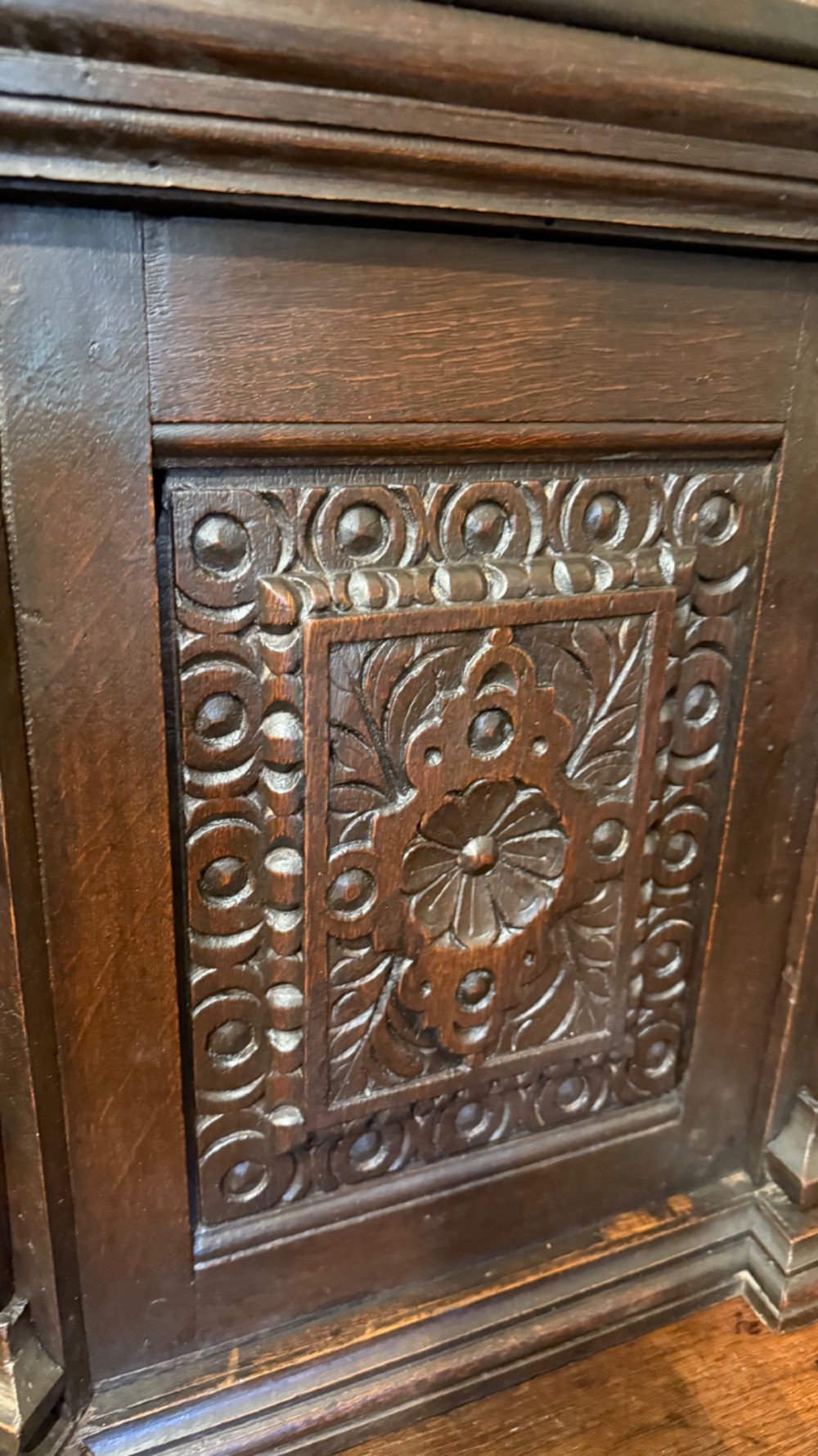 An 18th-century dark oak hanging cupboard featuring carved figural columns, relief door panels with floral motifs, and carved masks. View VIII