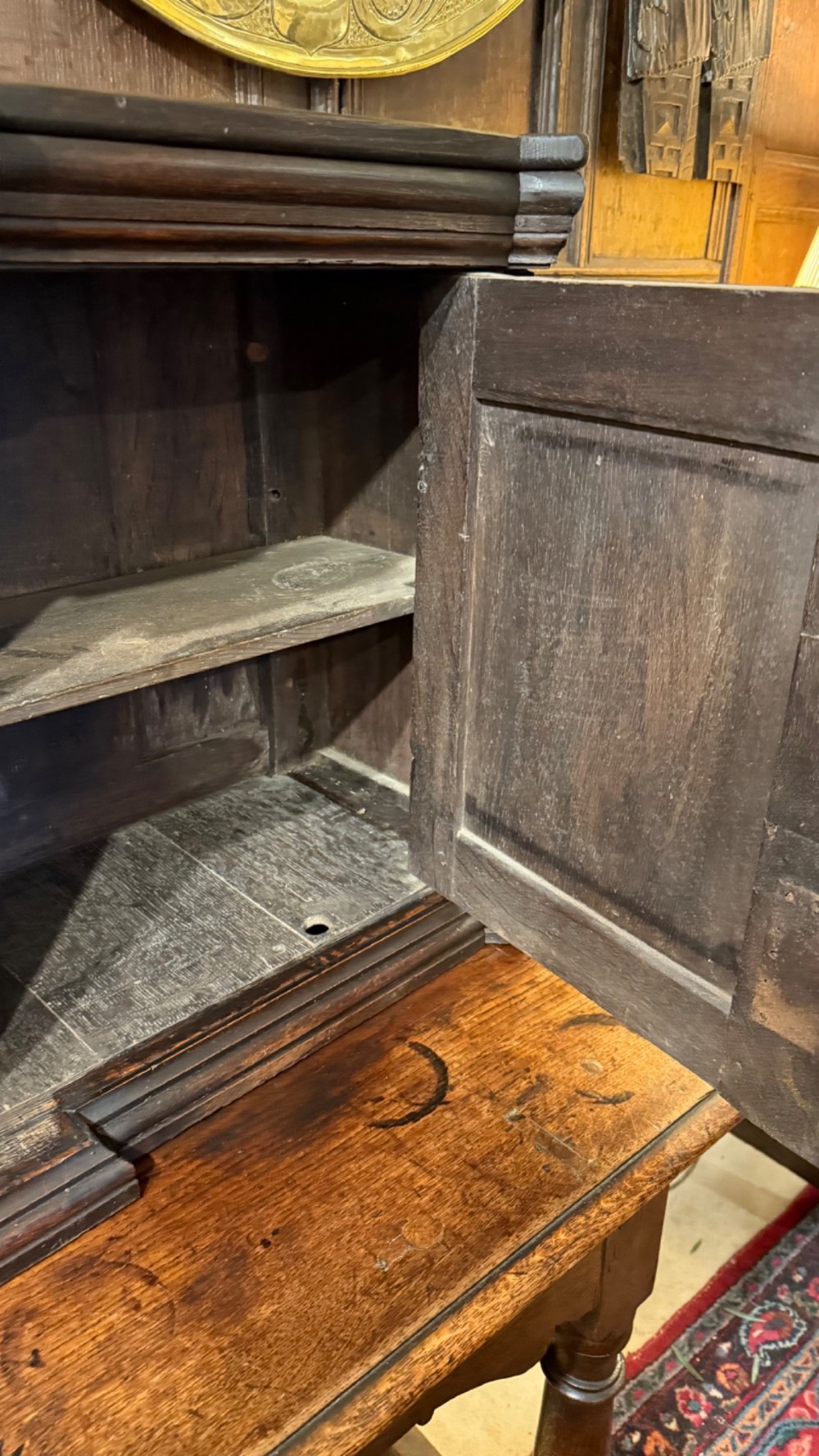 An 18th-century dark oak hanging cupboard featuring carved figural columns, relief door panels with floral motifs, and carved masks. View XIV