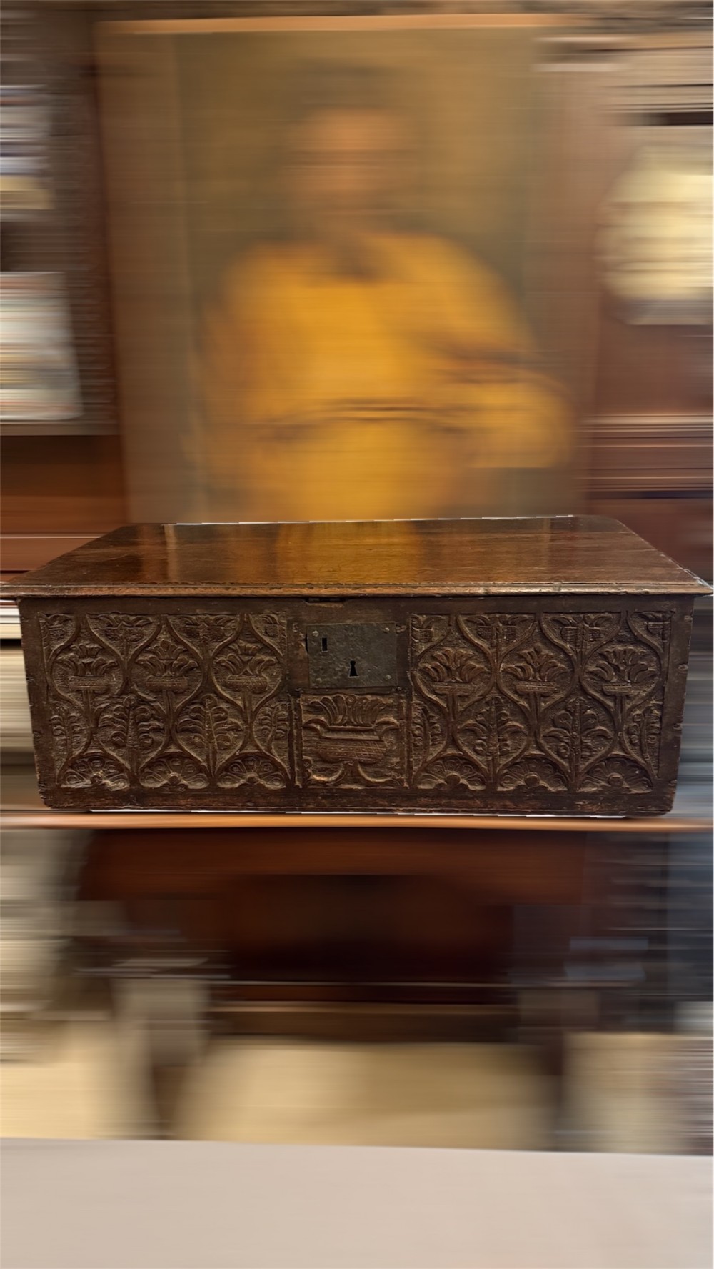 A 17th-century English oak bible box featuring relief carvings of foliate patterns across the front panel and a central iron lock plate. View II