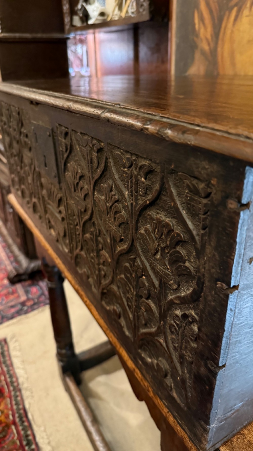 A 17th-century English oak bible box featuring relief carvings of foliate patterns across the front panel and a central iron lock plate. View VI