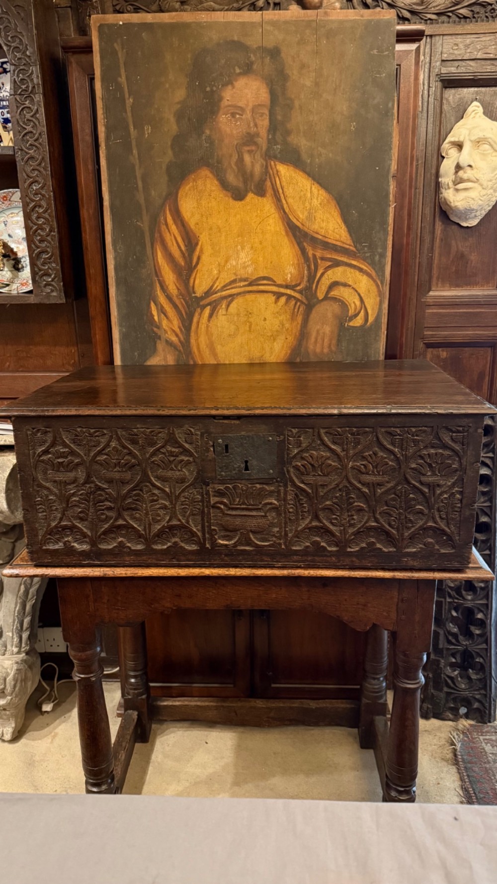 A 17th-century English oak bible box featuring relief carvings of foliate patterns across the front panel and a central iron lock plate. View VIII
