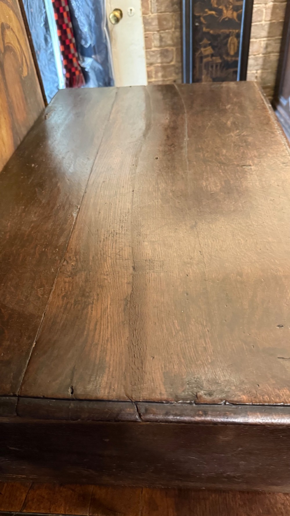 A 17th-century English oak bible box featuring relief carvings of foliate patterns across the front panel and a central iron lock plate. View XI