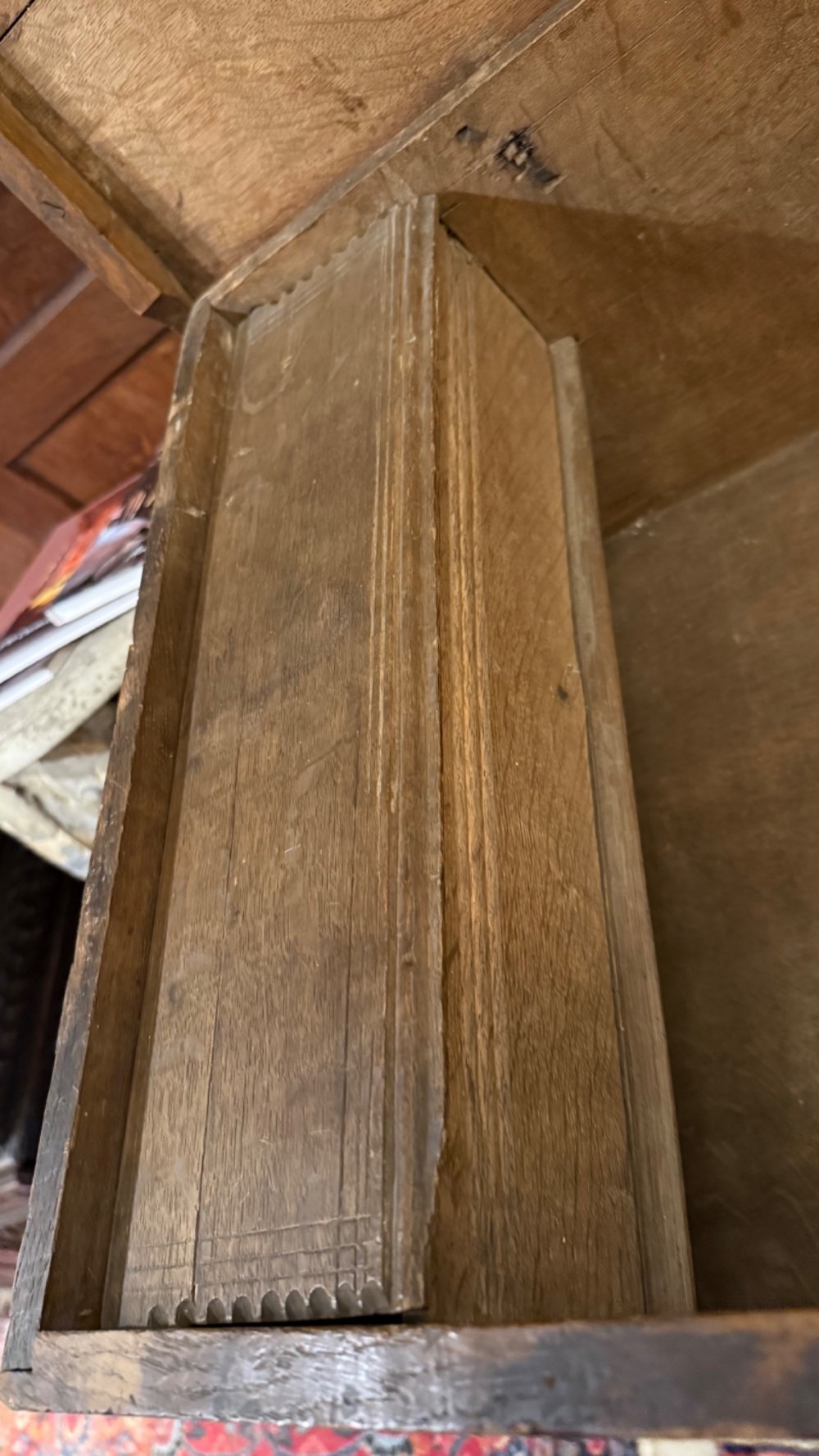 A 17th-century English oak bible box featuring relief carvings of foliate patterns across the front panel and a central iron lock plate. View XII