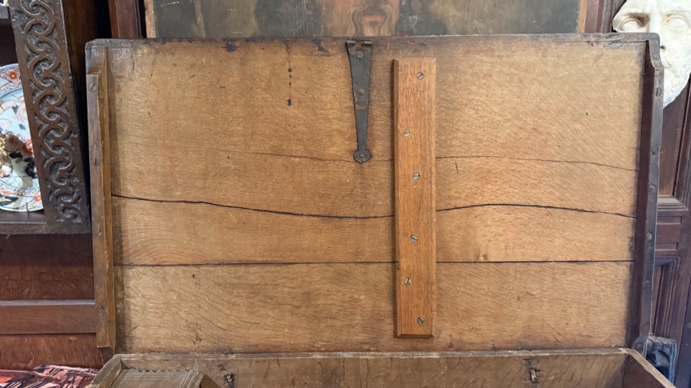 A 17th-century English oak bible box featuring relief carvings of foliate patterns across the front panel and a central iron lock plate. View XIV