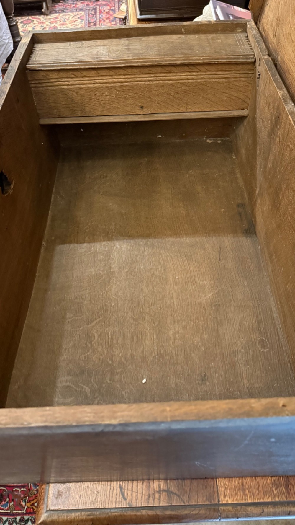 A 17th-century English oak bible box featuring relief carvings of foliate patterns across the front panel and a central iron lock plate. View XV