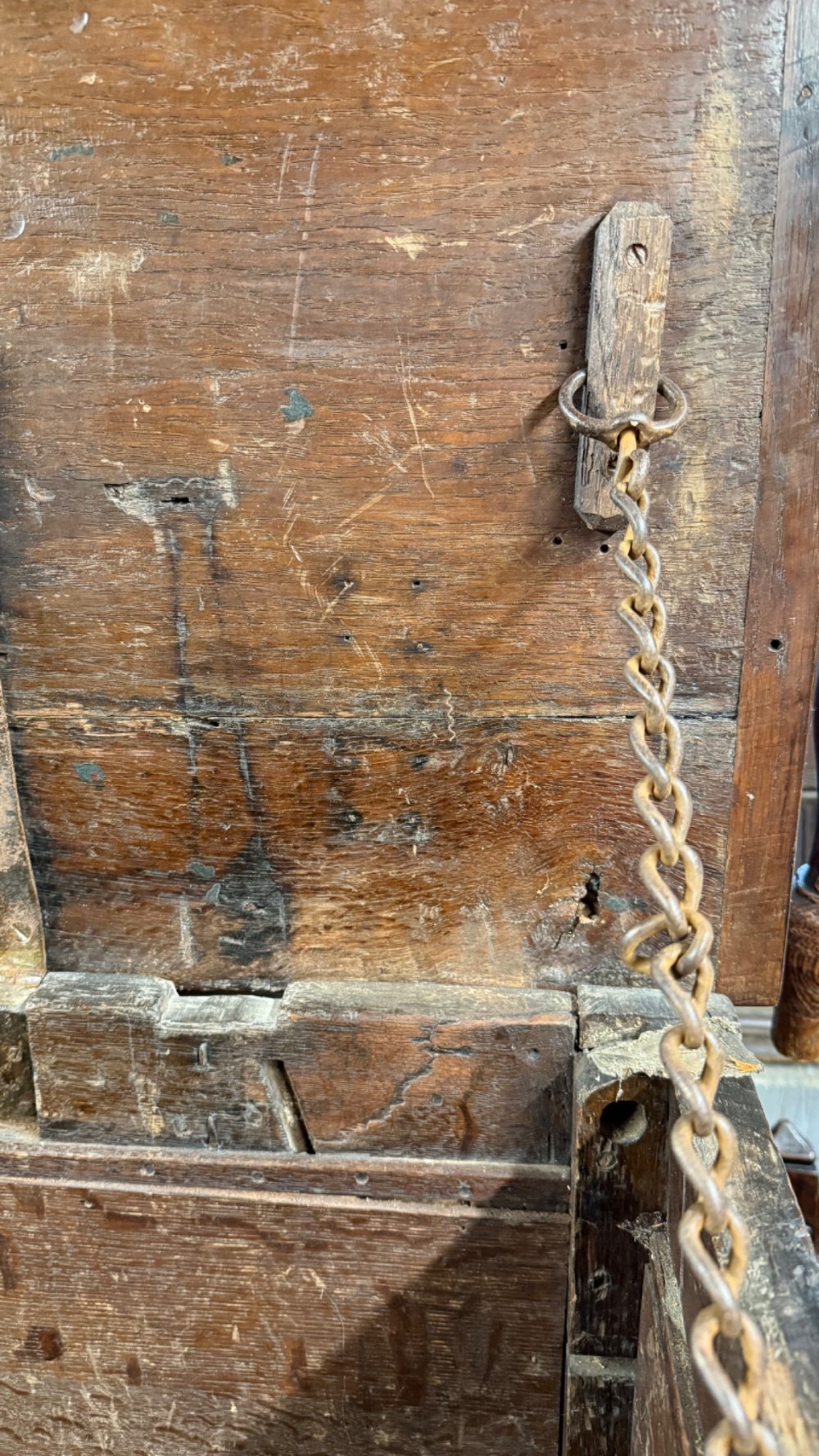 A 17th-century dark oak coffer featuring carved arcaded detail above geometrically moulded panel fronts and a central iron keyhole escutcheon. View XII