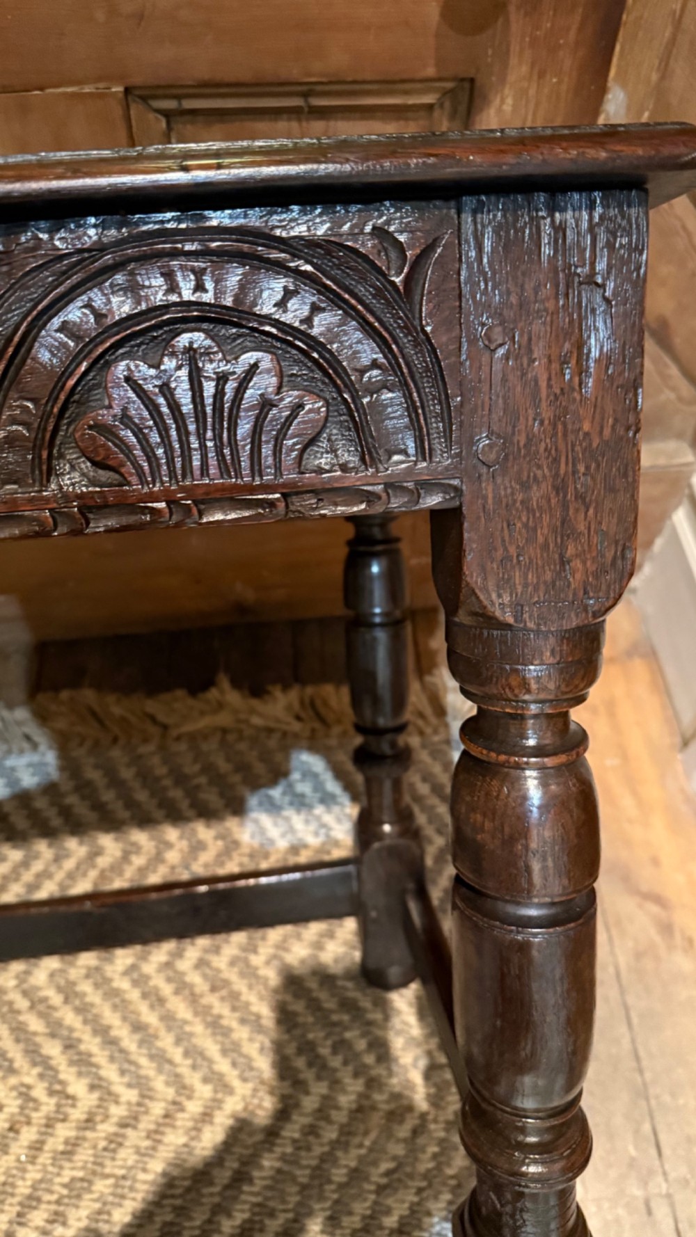 A dark oak 17th-century centre table featuring a carved fan-pattern apron, turned baluster legs, and sturdy wooden stretchers. View II