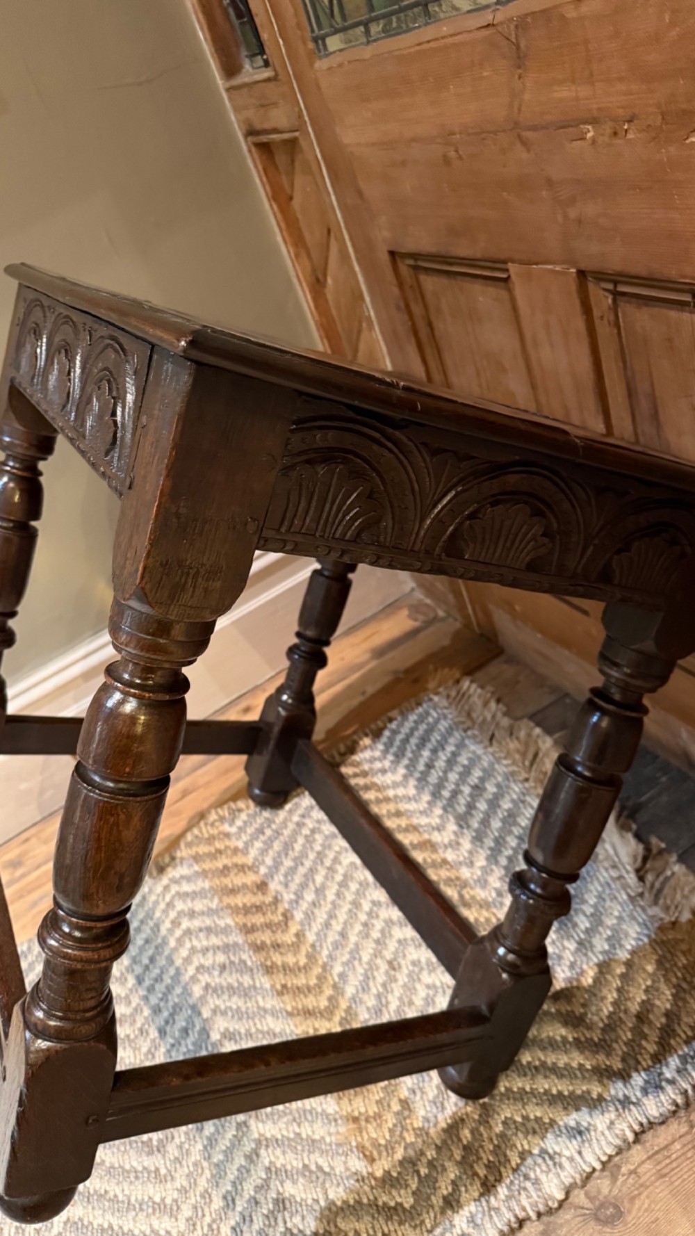 A dark oak 17th-century centre table featuring a carved fan-pattern apron, turned baluster legs, and sturdy wooden stretchers. View VI