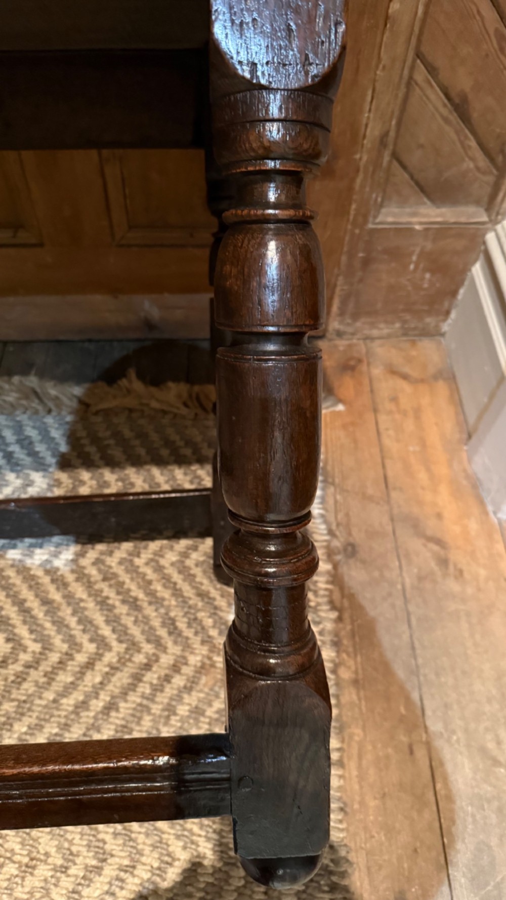 A dark oak 17th-century centre table featuring a carved fan-pattern apron, turned baluster legs, and sturdy wooden stretchers. View VII