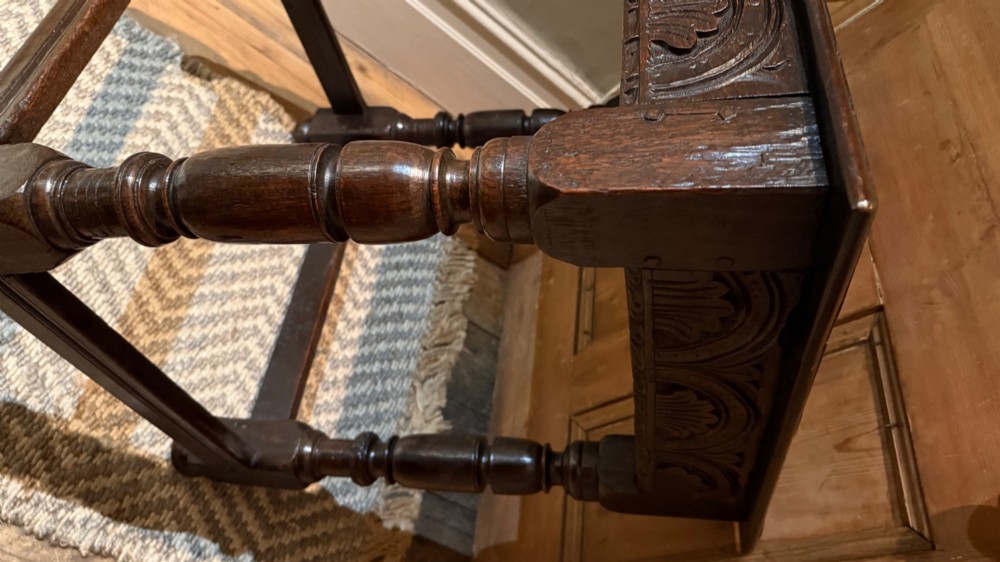A dark oak 17th-century centre table featuring a carved fan-pattern apron, turned baluster legs, and sturdy wooden stretchers. View VIII