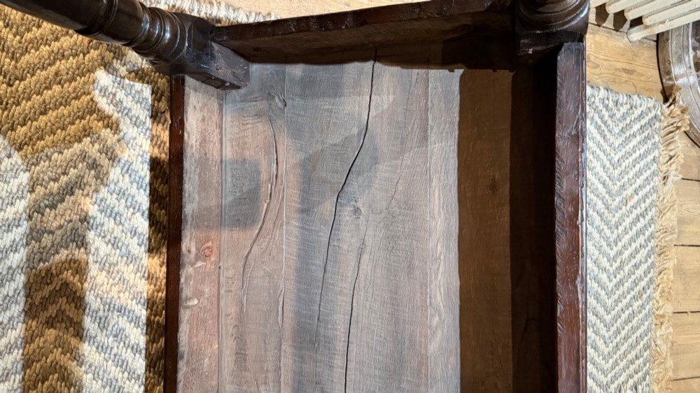 A dark oak 17th-century centre table featuring a carved fan-pattern apron, turned baluster legs, and sturdy wooden stretchers. View IX