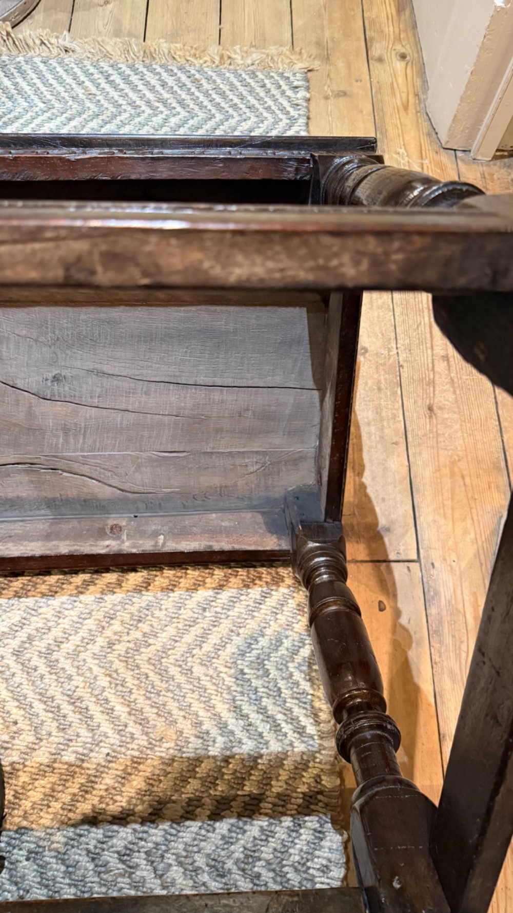 A dark oak 17th-century centre table featuring a carved fan-pattern apron, turned baluster legs, and sturdy wooden stretchers. View X