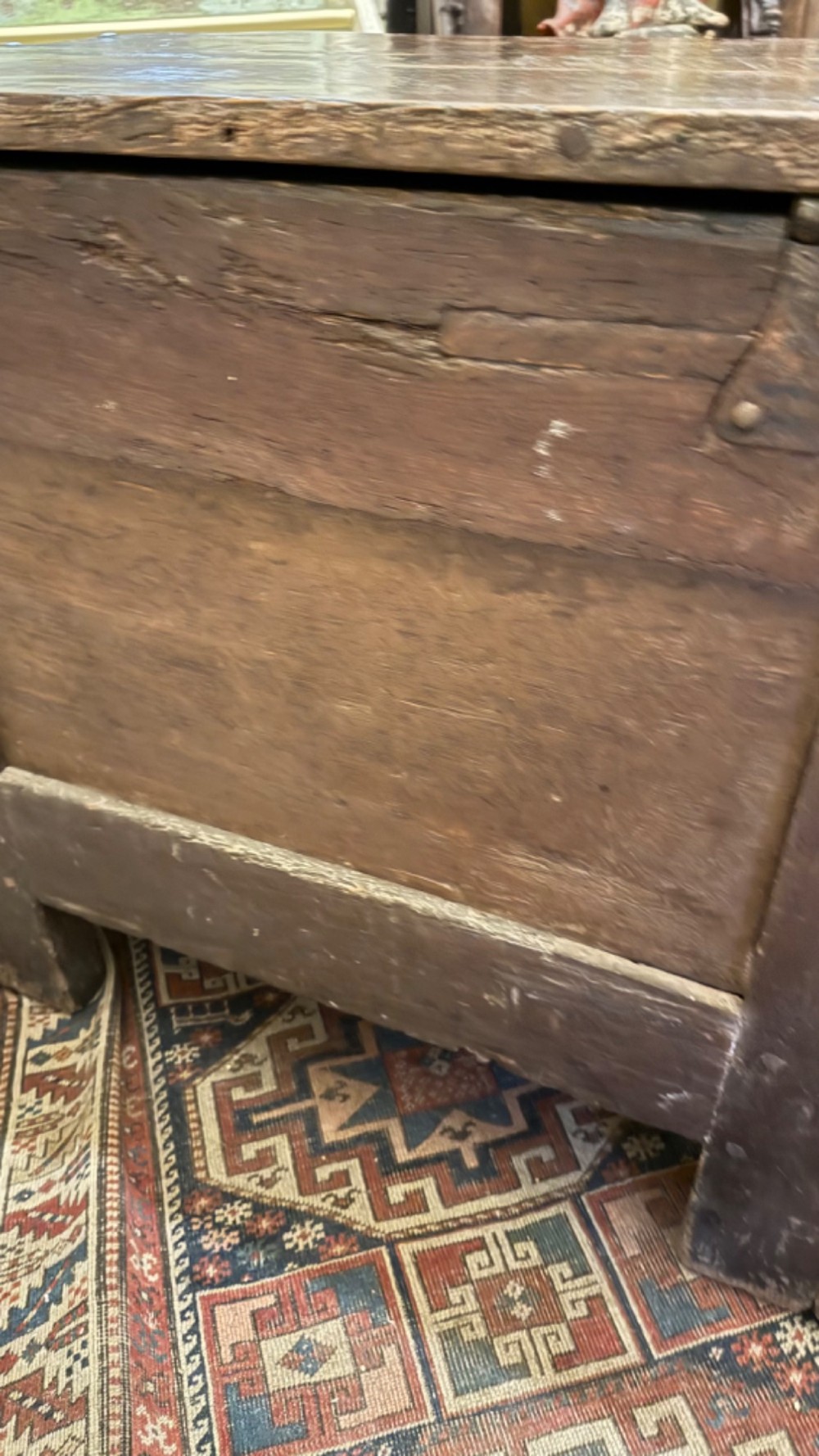 A dark brown 16th-century oak coffer featuring three front panels carved with gothic tracery and a central iron lockplate. View XIII