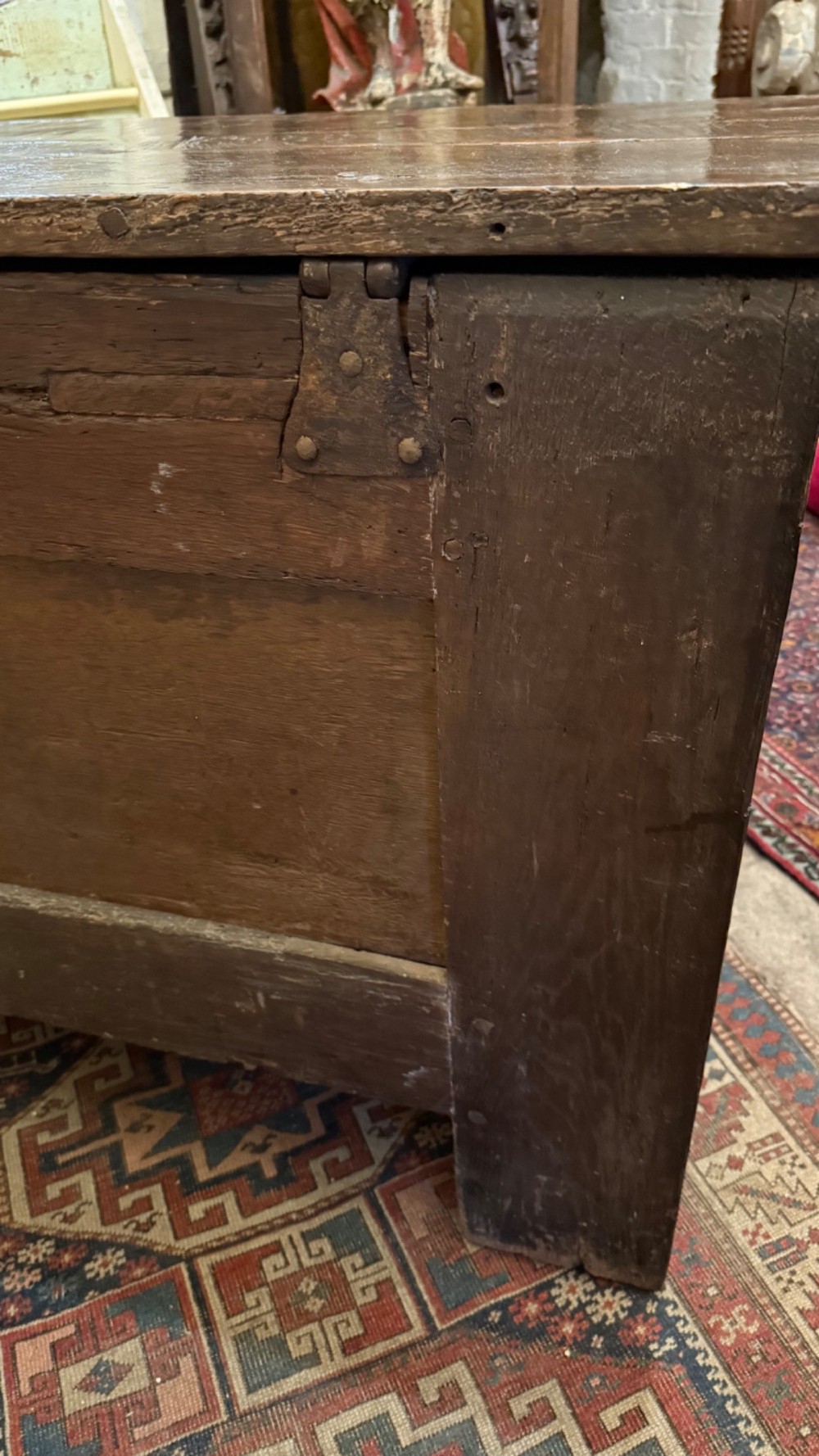 A dark brown 16th-century oak coffer featuring three front panels carved with gothic tracery and a central iron lockplate. View XIV