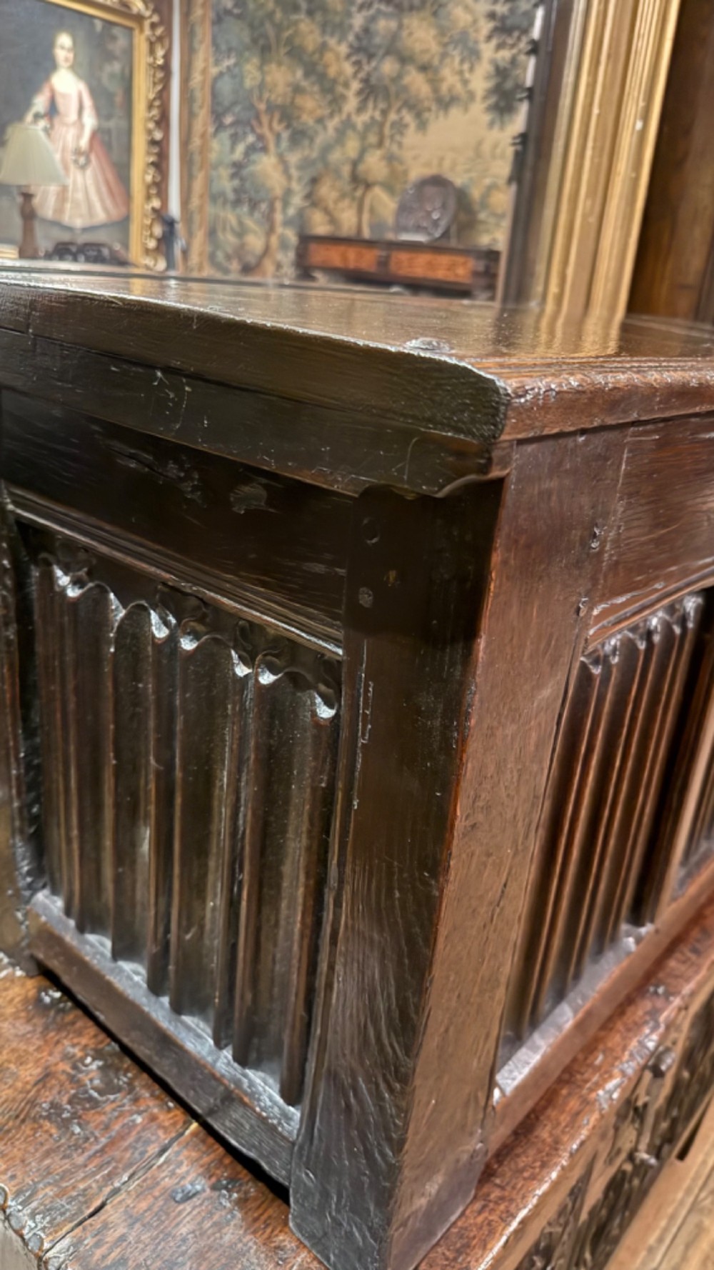 A 16th century carved oak coffer featuring double linenfold carved front panels and a large central iron lockplate. View II