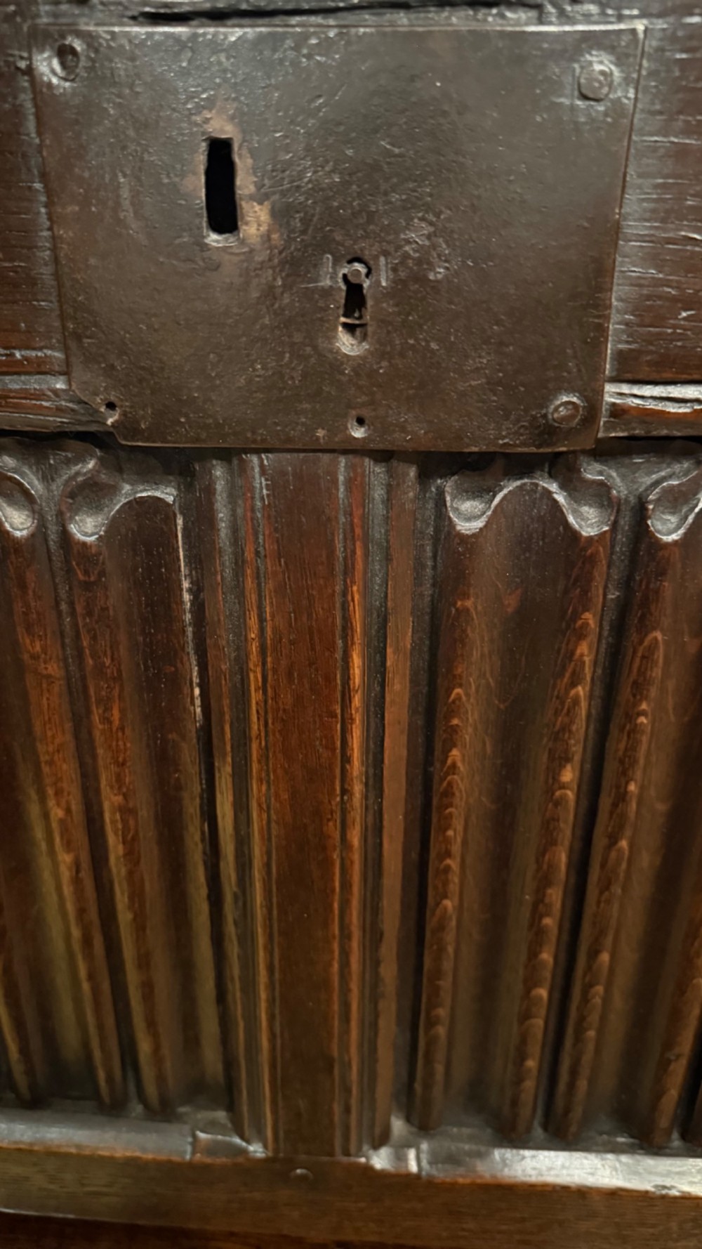 A 16th century carved oak coffer featuring double linenfold carved front panels and a large central iron lockplate. View V