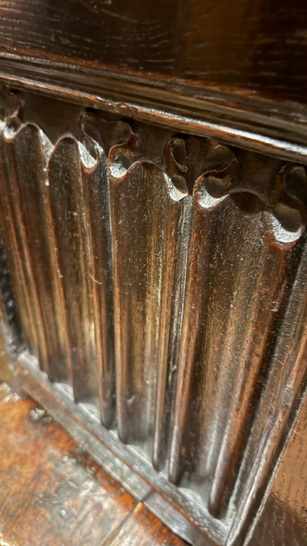 A 16th century carved oak coffer featuring double linenfold carved front panels and a large central iron lockplate. View VI
