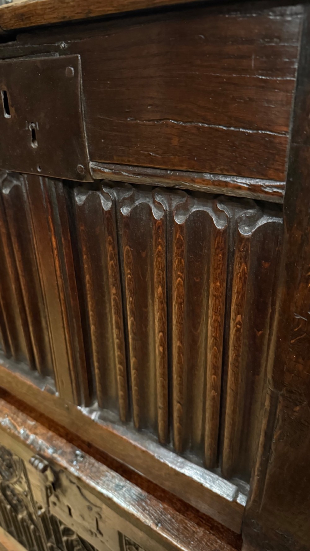 A 16th century carved oak coffer featuring double linenfold carved front panels and a large central iron lockplate. View VII