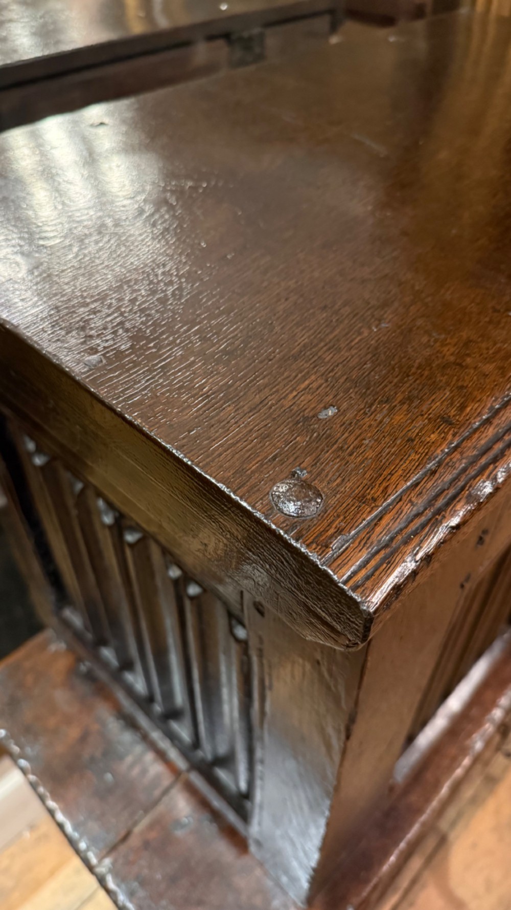 A 16th century carved oak coffer featuring double linenfold carved front panels and a large central iron lockplate. View VIII