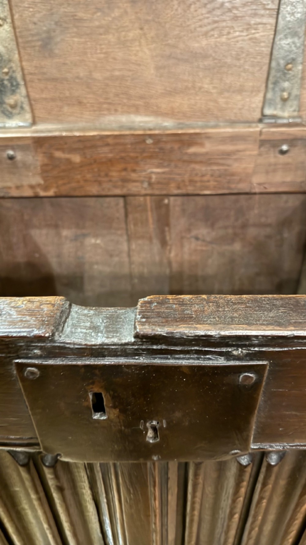 A 16th century carved oak coffer featuring double linenfold carved front panels and a large central iron lockplate. View XII