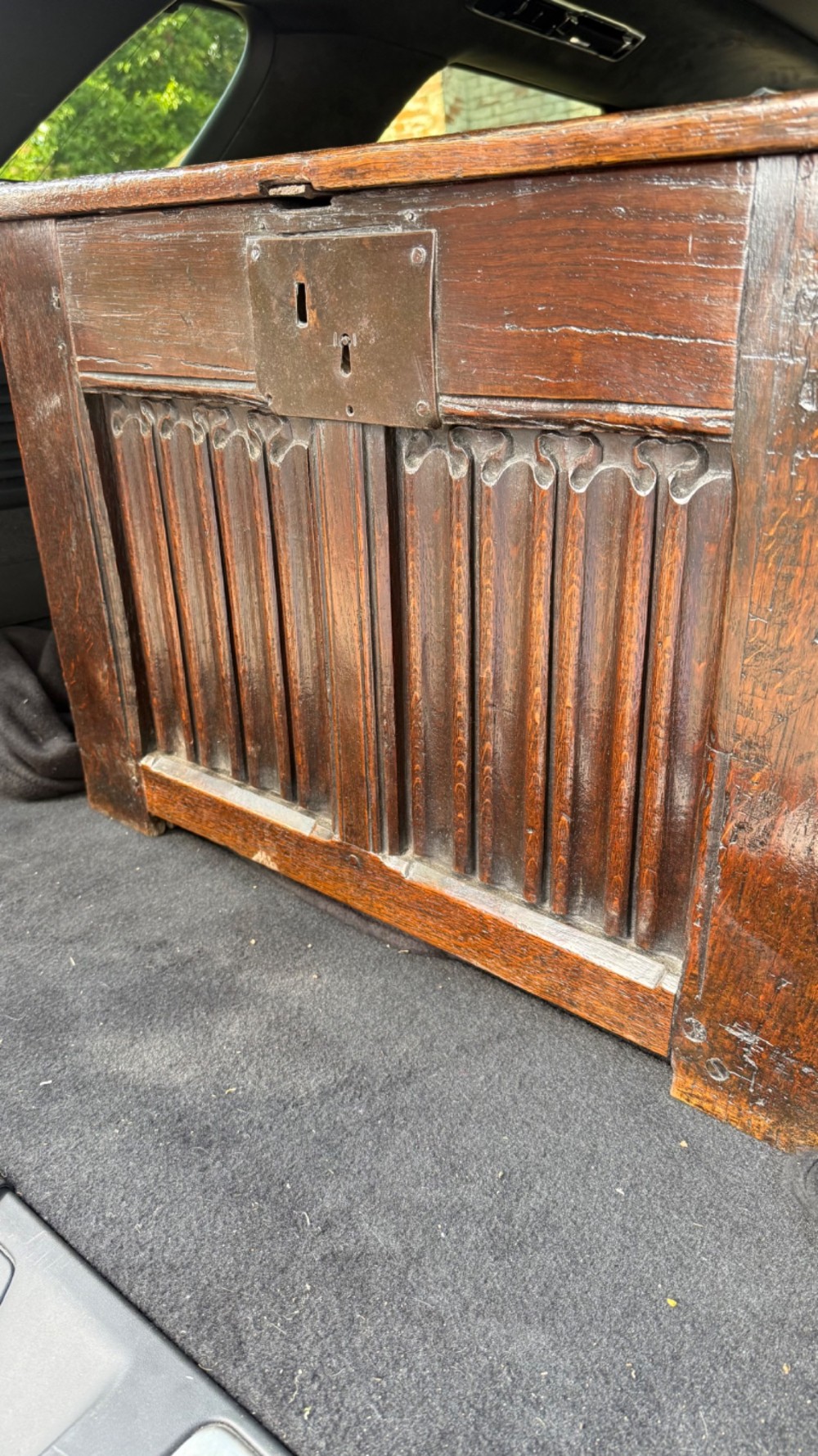 A 16th century carved oak coffer featuring double linenfold carved front panels and a large central iron lockplate. View XV