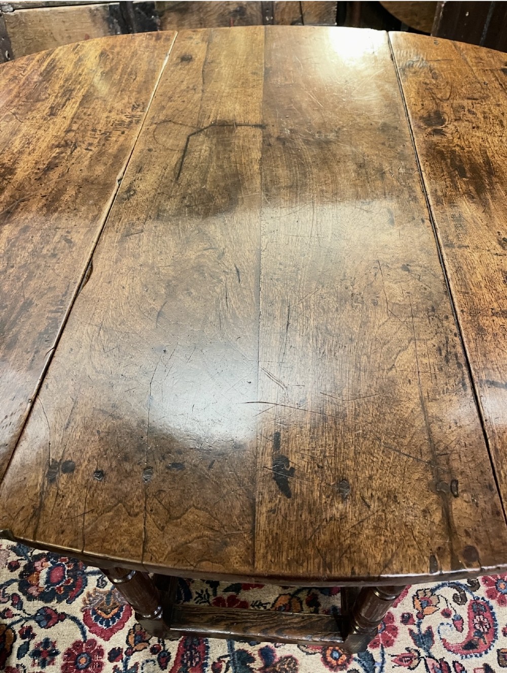 An 18th-century walnut gateleg table featuring an oval drop-leaf top supported by turned legs. View IV
