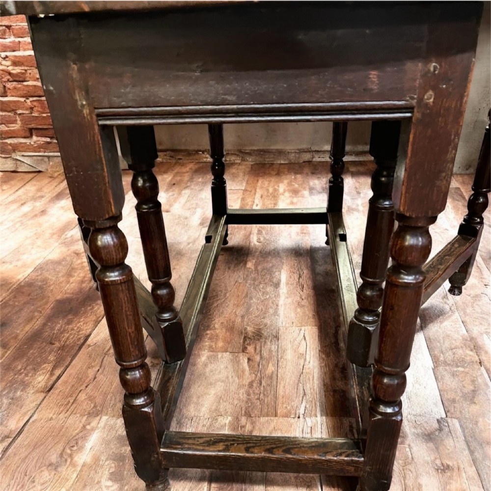 An 18th-century walnut gateleg table featuring an oval drop-leaf top supported by turned legs. View VI