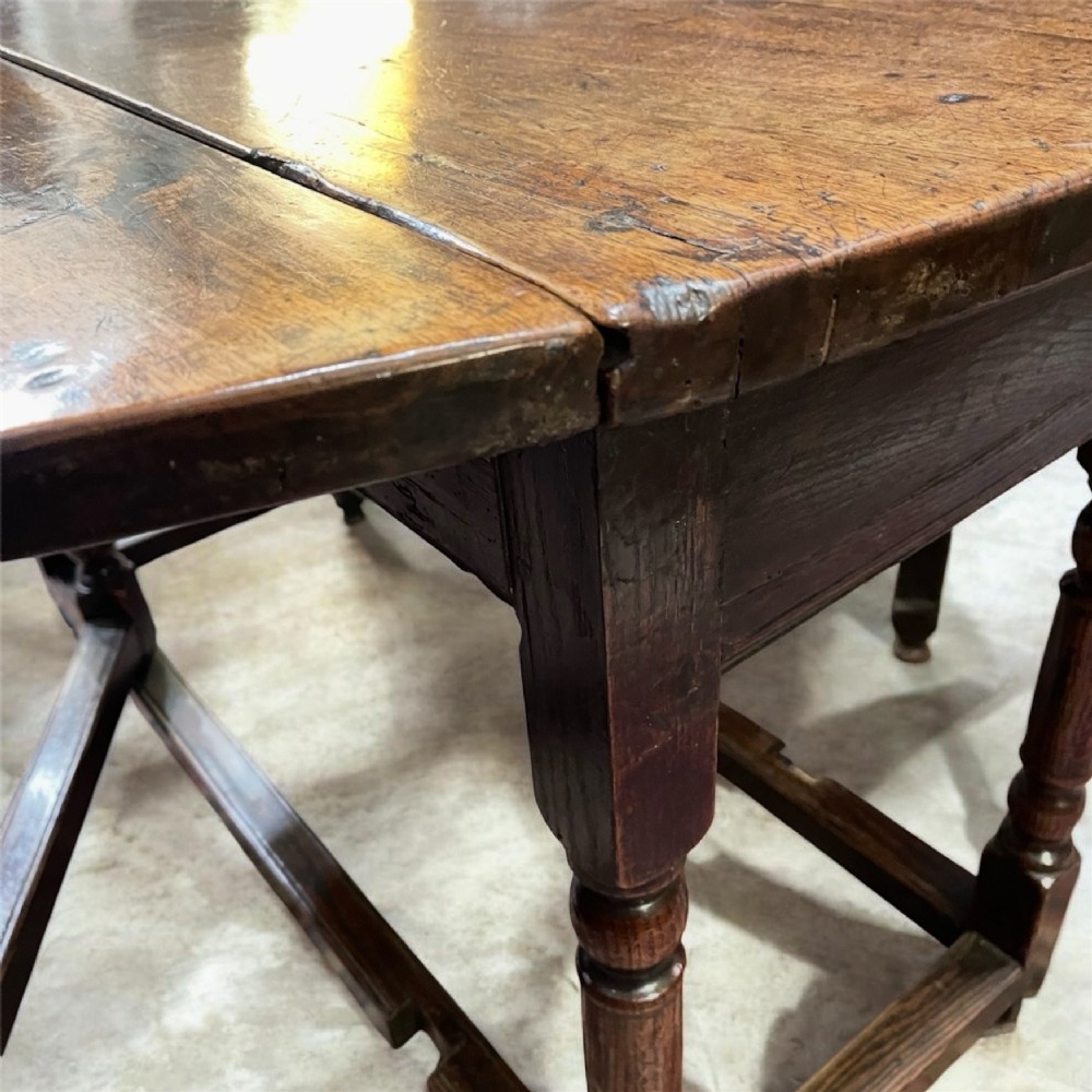 An 18th-century walnut gateleg table featuring an oval drop-leaf top supported by turned legs. View XII