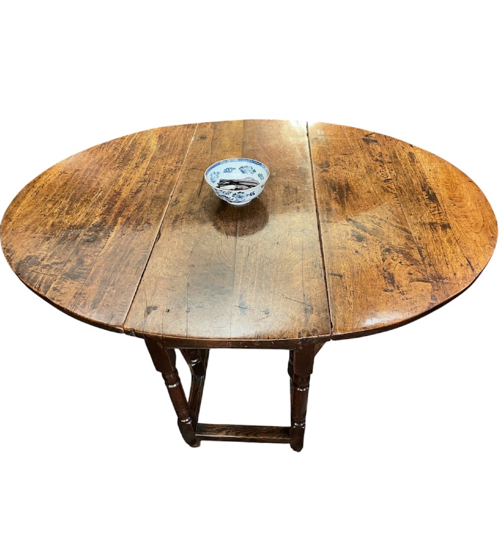 An 18th-century walnut gateleg table featuring an oval drop-leaf top supported by turned legs. View XIII