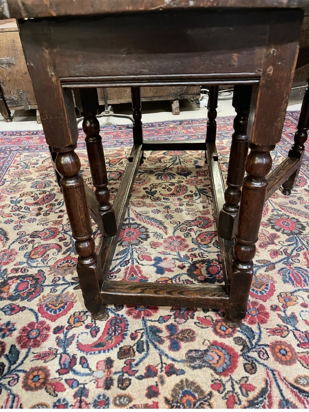 An 18th-century walnut gateleg table featuring an oval drop-leaf top supported by turned legs. View XV