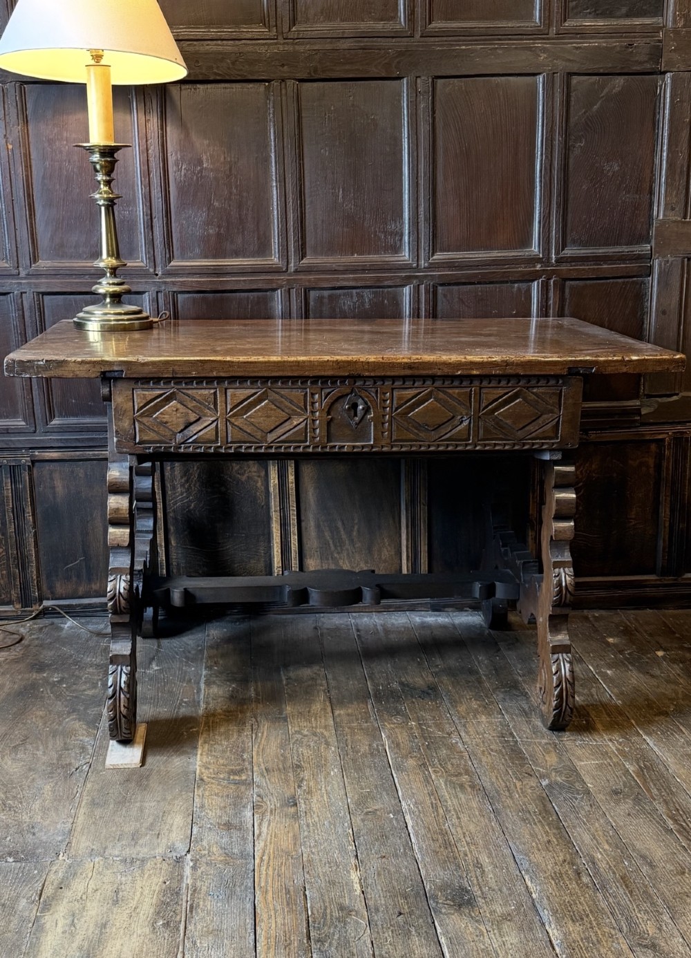 A 17th-century dark walnut side table featuring a geometrically carved single drawer, detailed trestle end supports, and a shaped central stretcher. View II