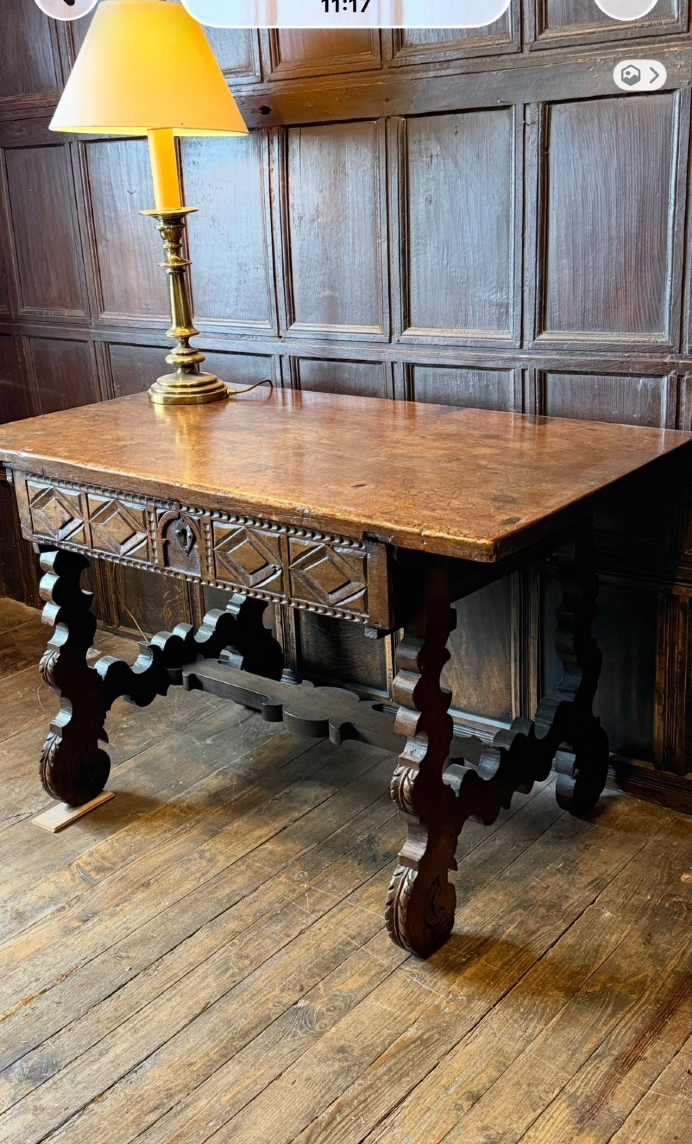 A 17th-century dark walnut side table featuring a geometrically carved single drawer, detailed trestle end supports, and a shaped central stretcher. View IX