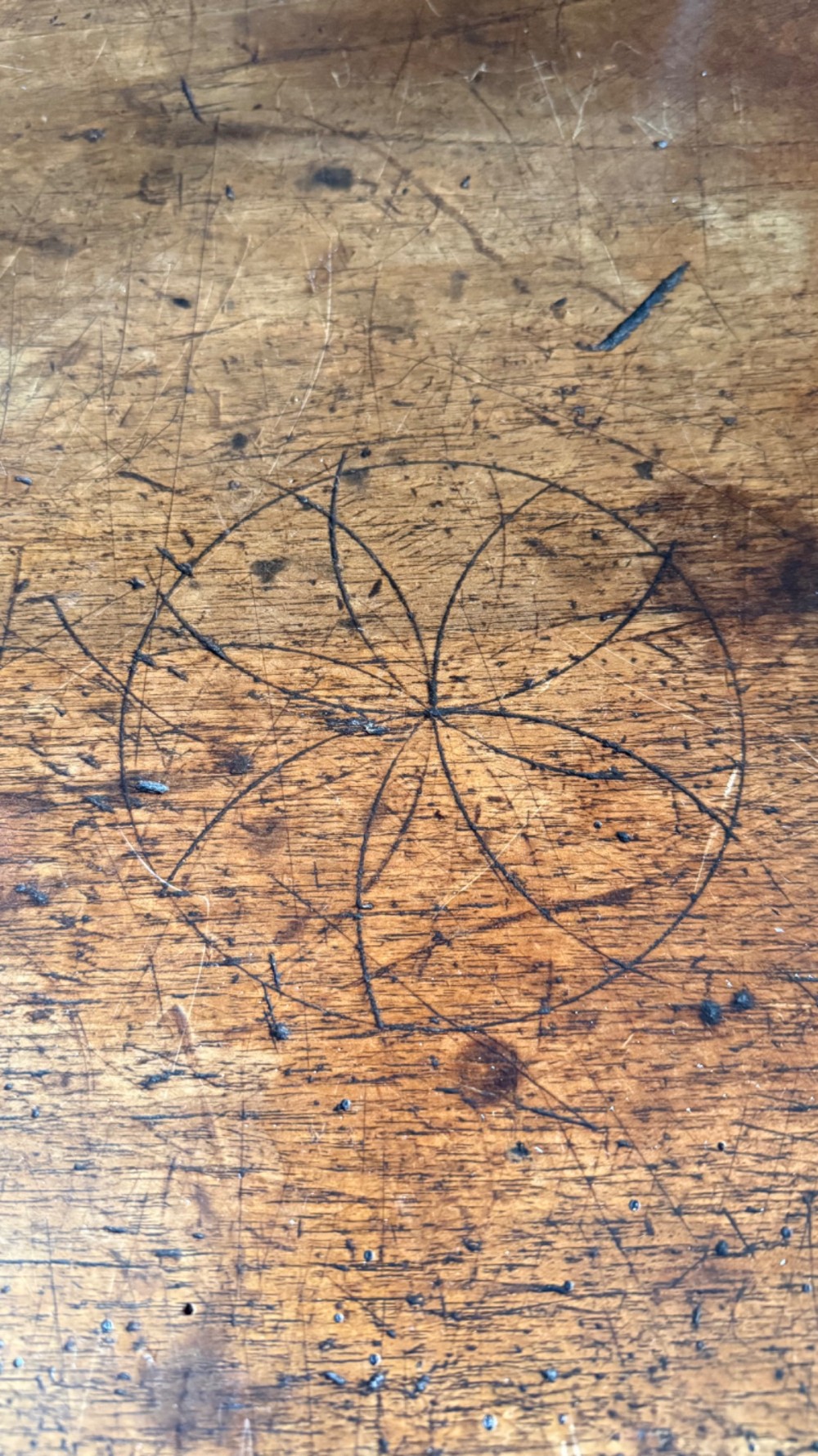 A 17th-century dark walnut side table featuring a geometrically carved single drawer, detailed trestle end supports, and a shaped central stretcher. View XI