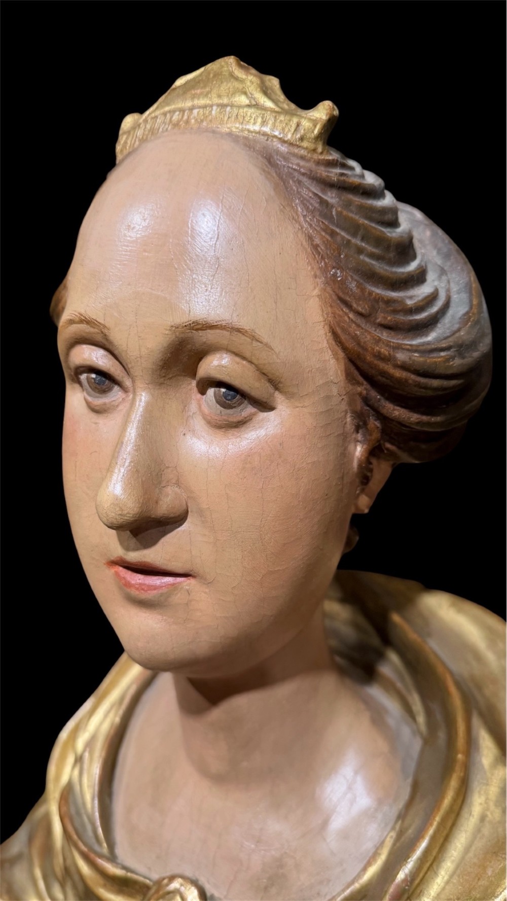 A seventeenth-century carved wooden bust of Saint Dorothea featuring gilded drapery and polychrome painted skin tones mounted on a decorative cartouche base. View II