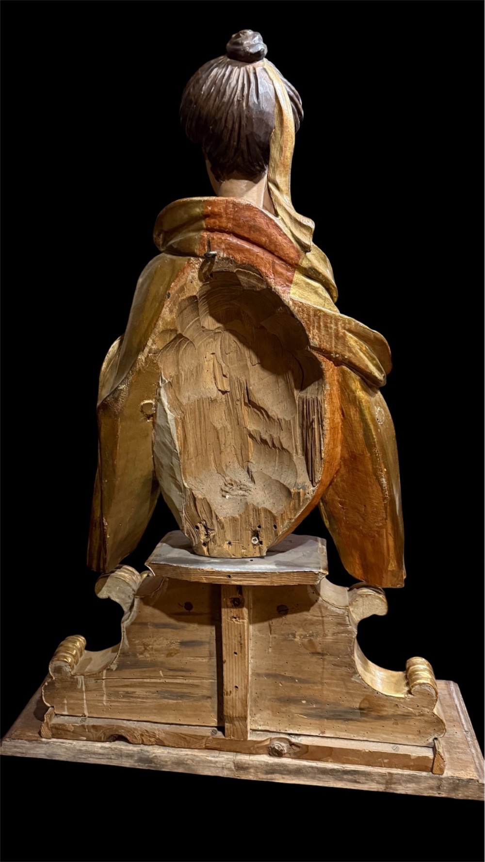 A seventeenth-century carved wooden bust of Saint Dorothea featuring gilded drapery and polychrome painted skin tones mounted on a decorative cartouche base. View X