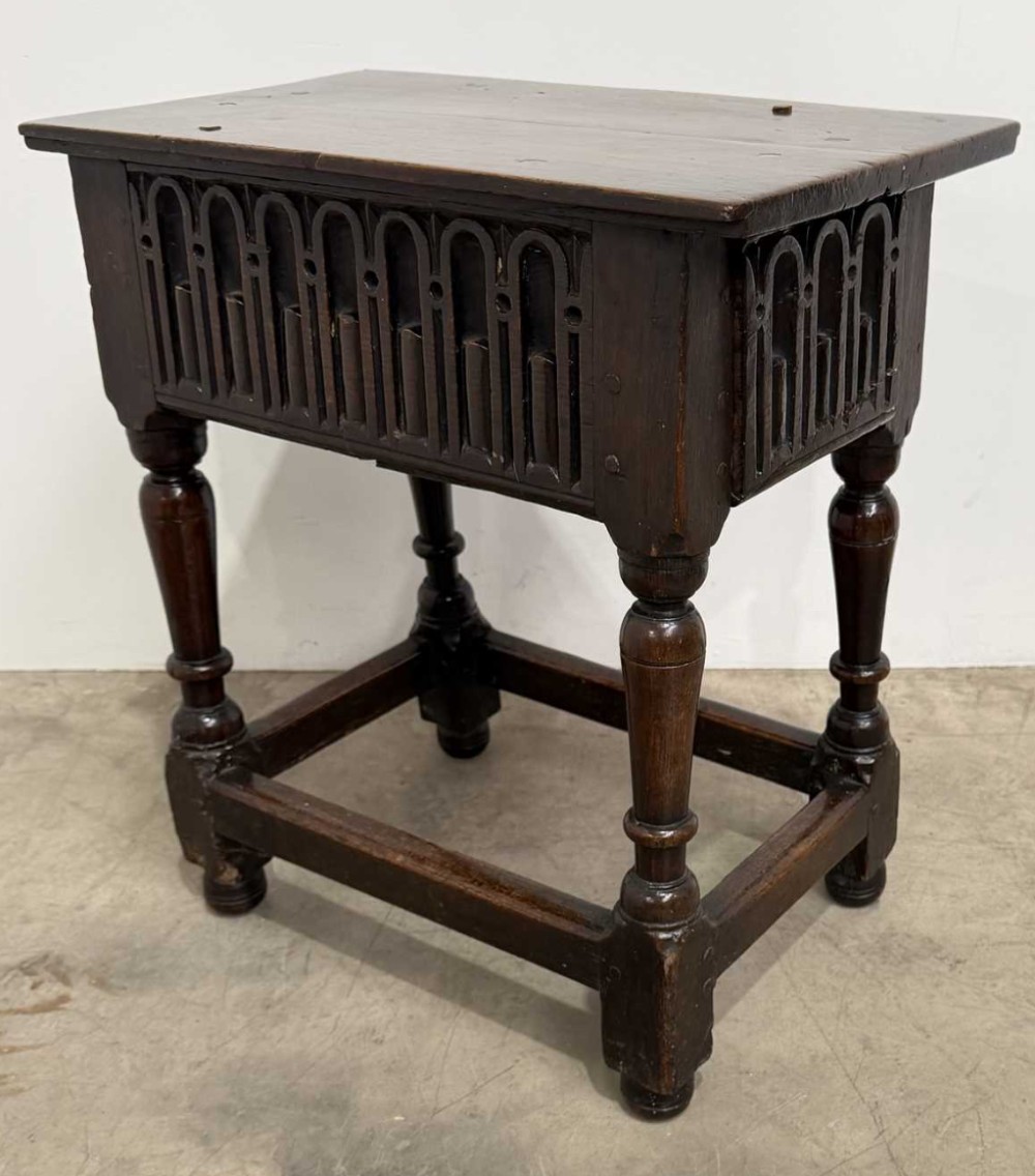 A 17th-century dark oak joint stool featuring a carved arcade frieze, turned legs, and sturdy base stretchers. View III