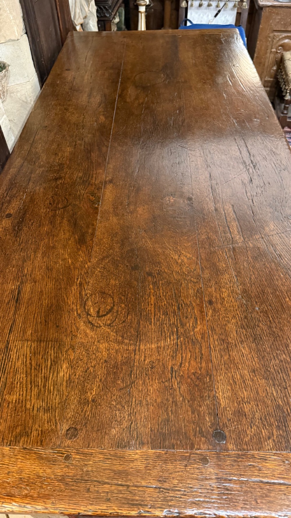 A 17th-century dark oak refectory dining table featuring a carved decorative frieze, turned baluster legs, and low perimeter stretchers. View XIII