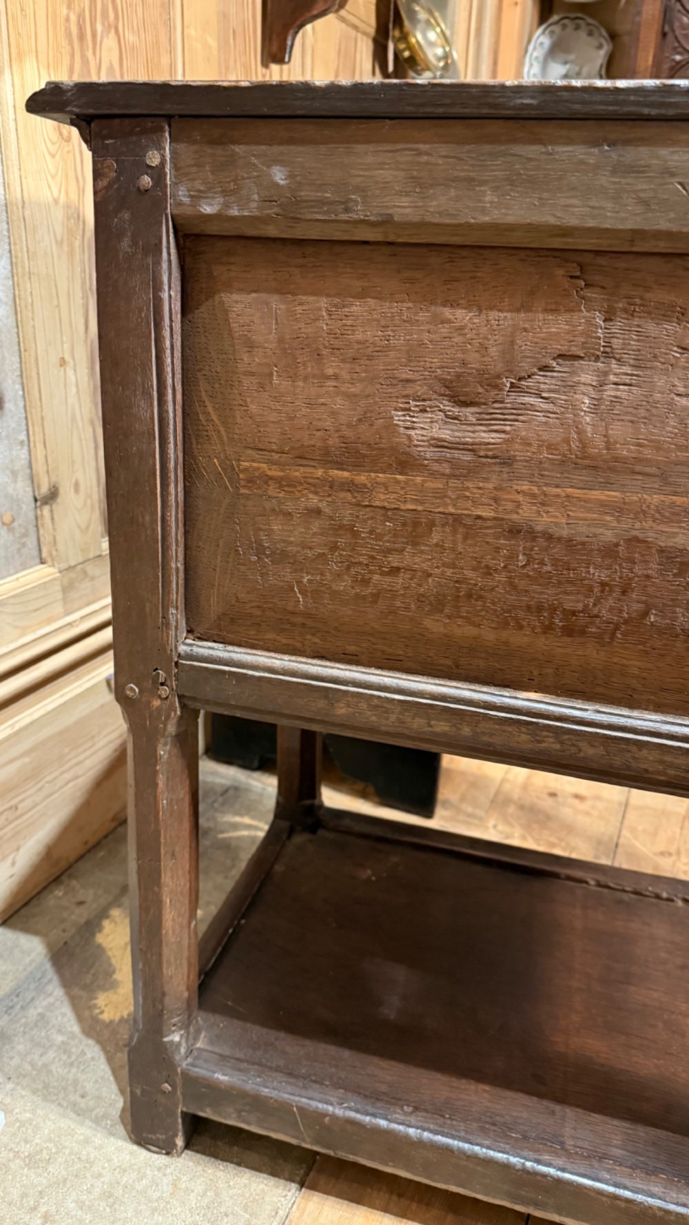 A 17th-century dark oak livery cupboard featuring a single door carved with initials and dated 1674, supported on upright legs with an open lower shelf. View X