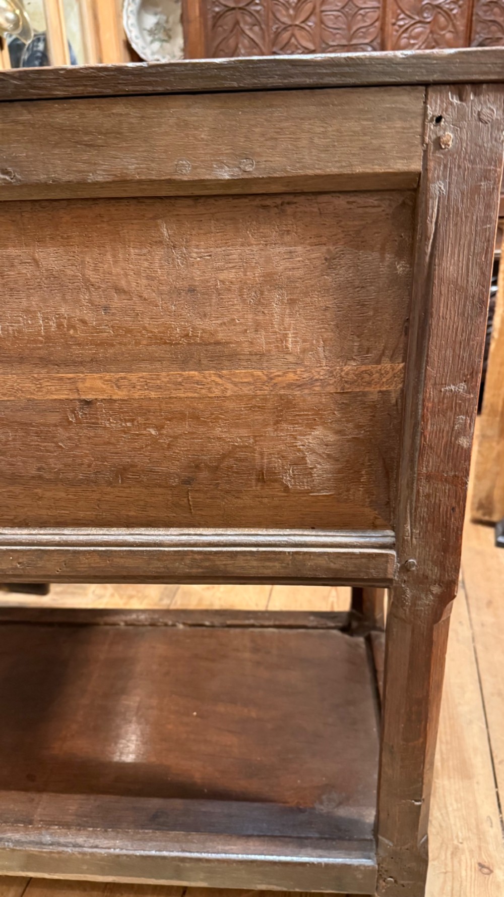 A 17th-century dark oak livery cupboard featuring a single door carved with initials and dated 1674, supported on upright legs with an open lower shelf. View XI