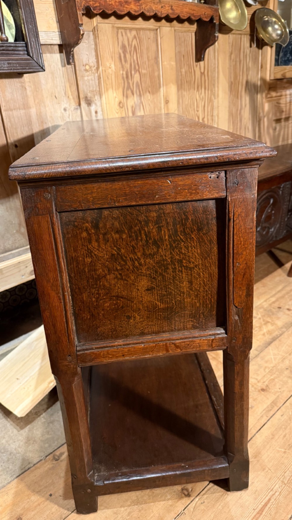 A 17th-century dark oak livery cupboard featuring a single door carved with initials and dated 1674, supported on upright legs with an open lower shelf. View XIII
