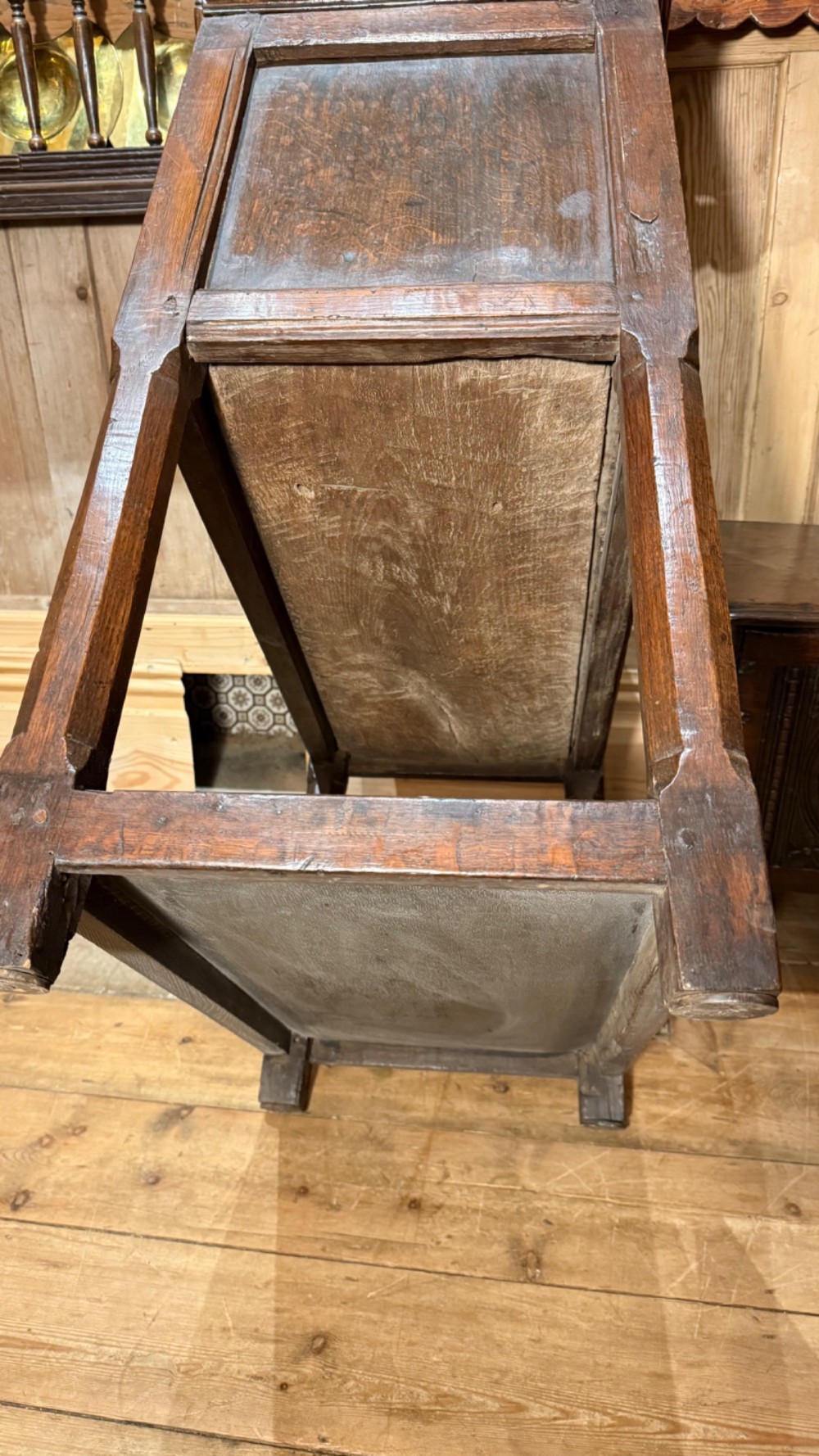 A 17th-century dark oak livery cupboard featuring a single door carved with initials and dated 1674, supported on upright legs with an open lower shelf. View XIV