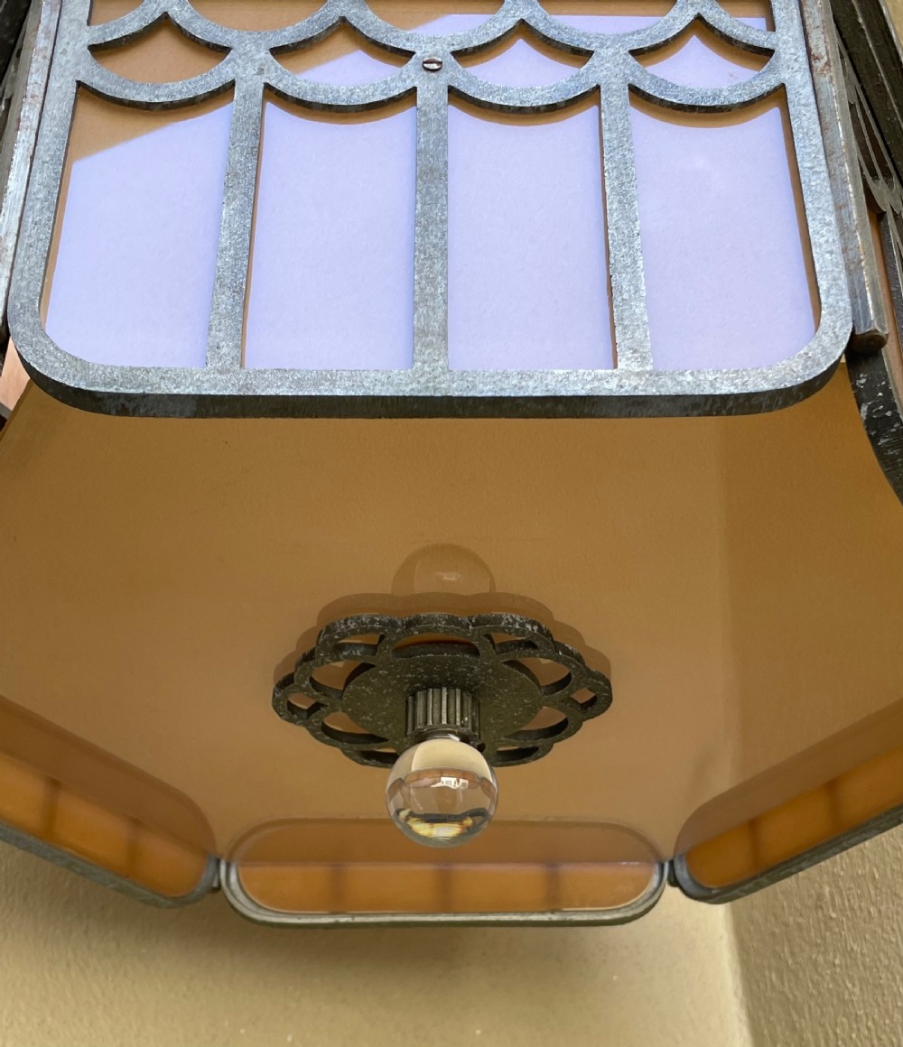 An Art Deco hexagonal flush ceiling light featuring frosted amber glass panels set within a scalloped metal frame and a central glass finial. View III