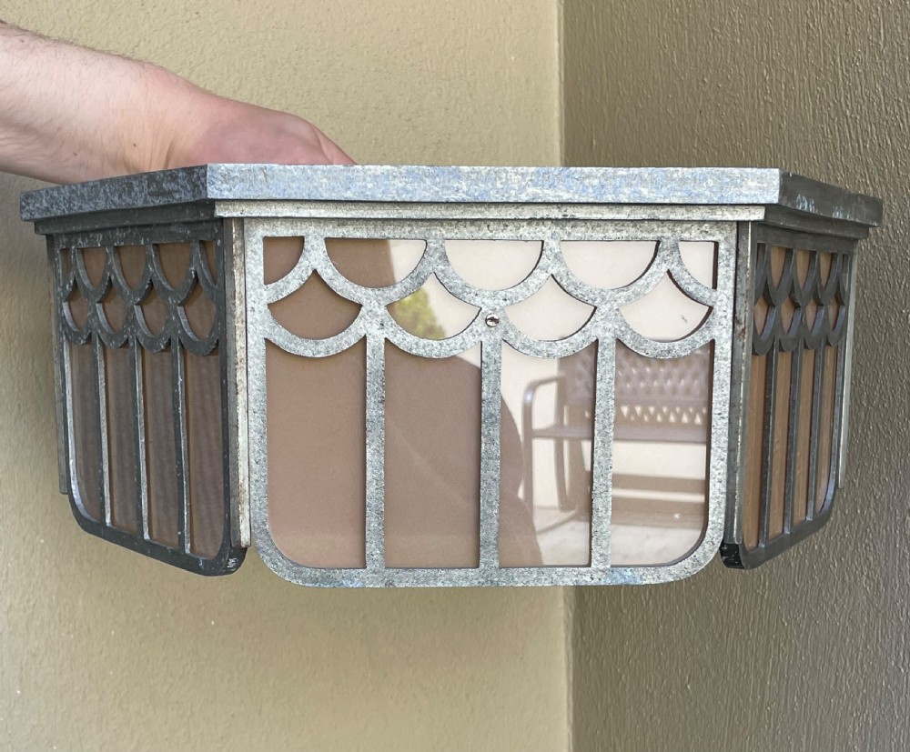 An Art Deco hexagonal flush ceiling light featuring frosted amber glass panels set within a scalloped metal frame and a central glass finial. View VI